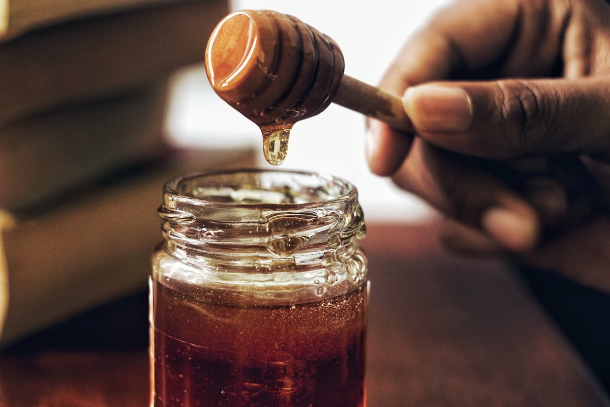 Honey dripping from a wooden dipper